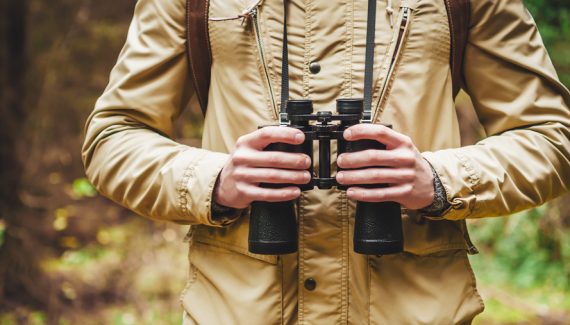 Hunter in the woods with binoculars